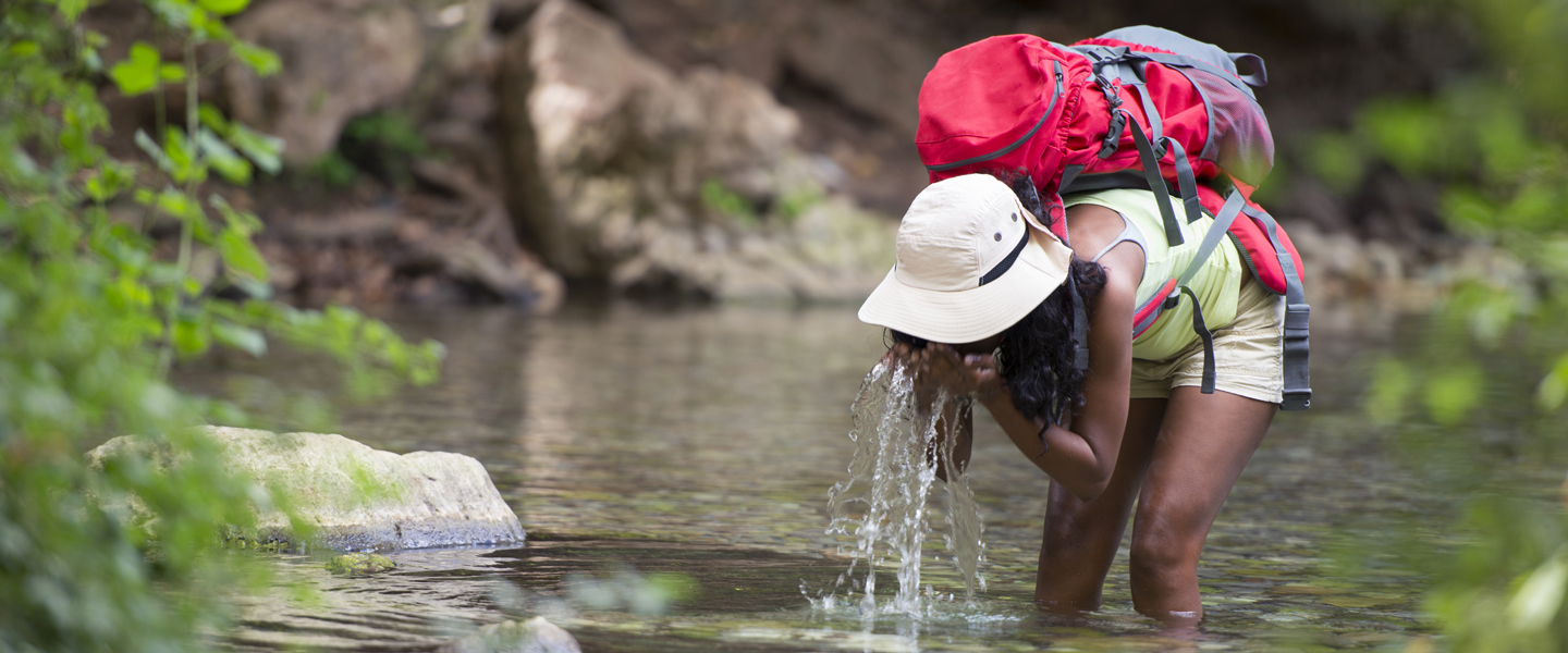 backpacker-tourist-woman-drinking-and-refreshing-iStock619523172-1440x600